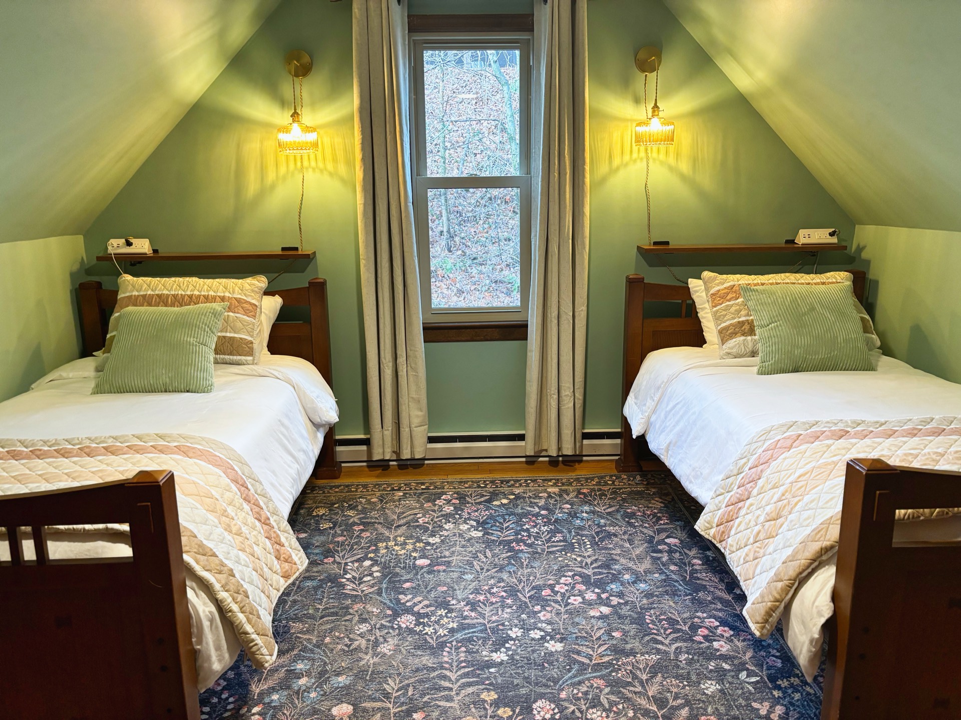 Cozy attic bedroom with twin beds and green walls