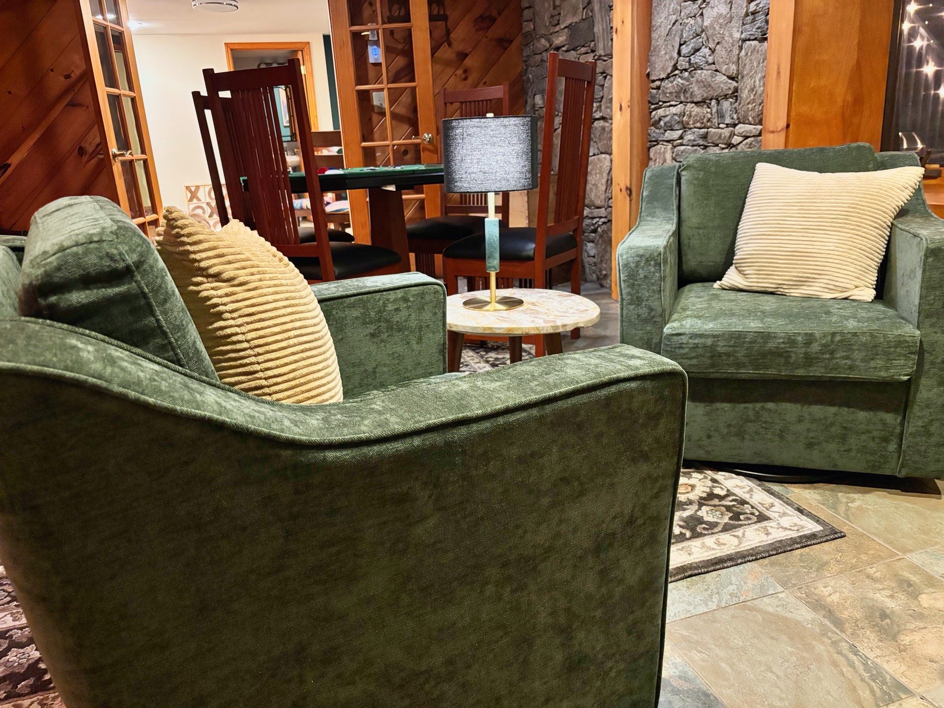 Lower level lounge with green velvet armchairs